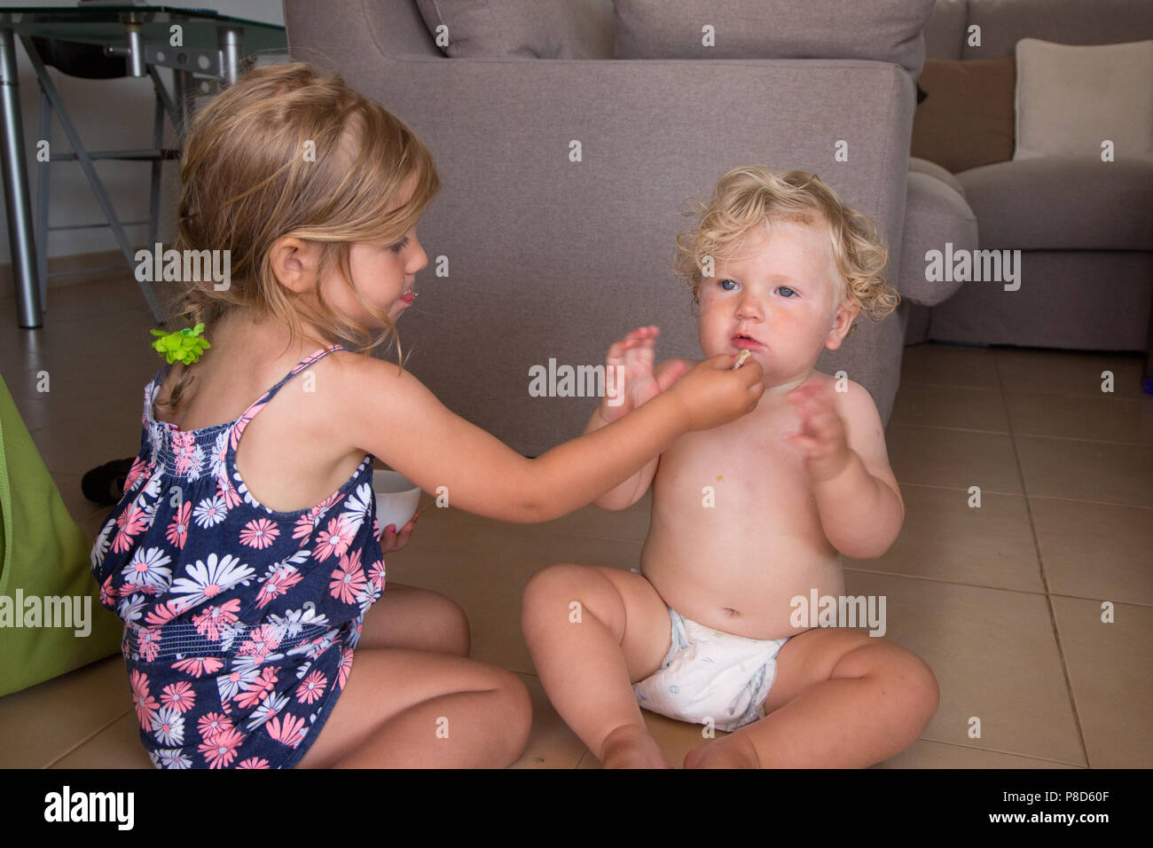 Une fillette d'un an se nourrir une banane Banque D'Images