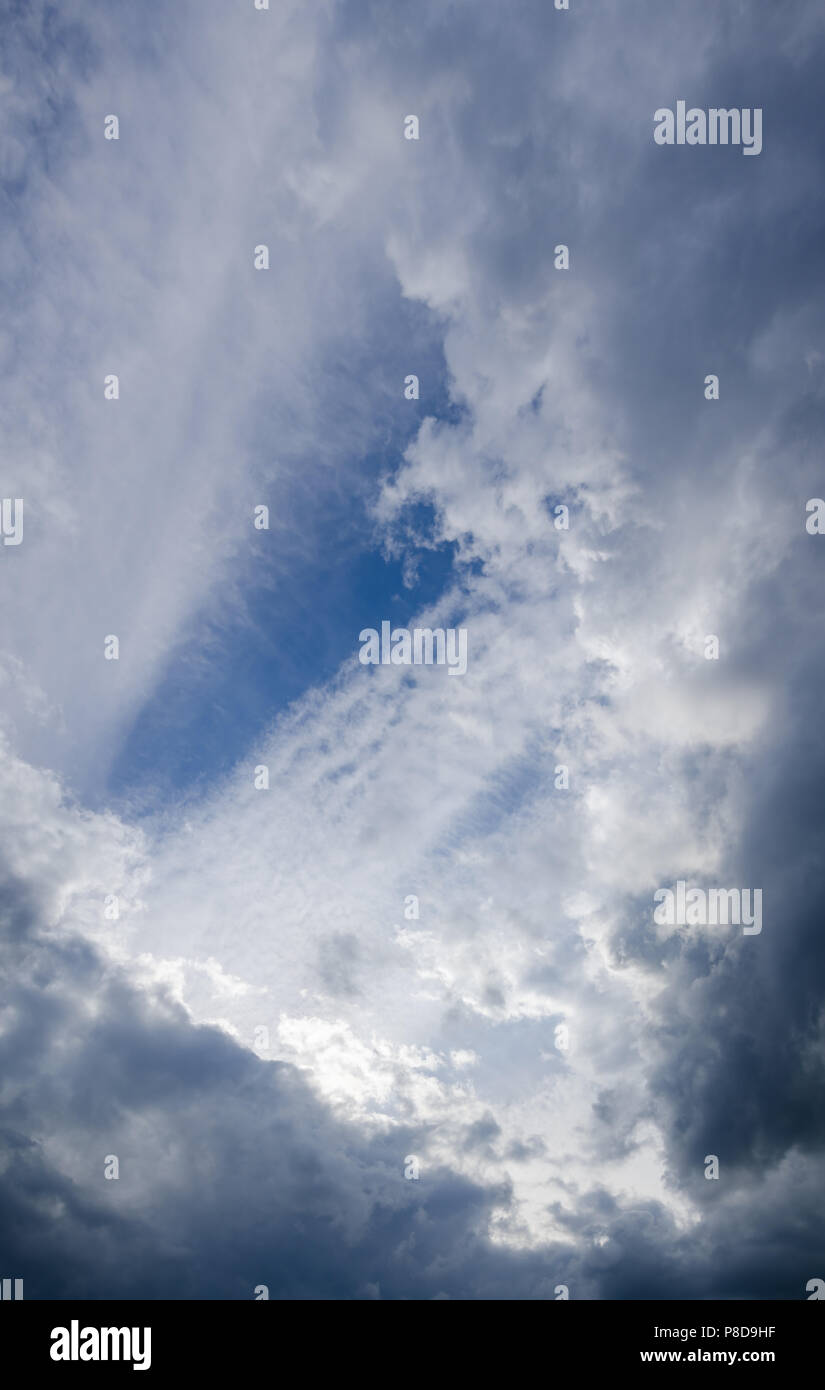 Fond bleu ciel avec nuages gris Banque D'Images