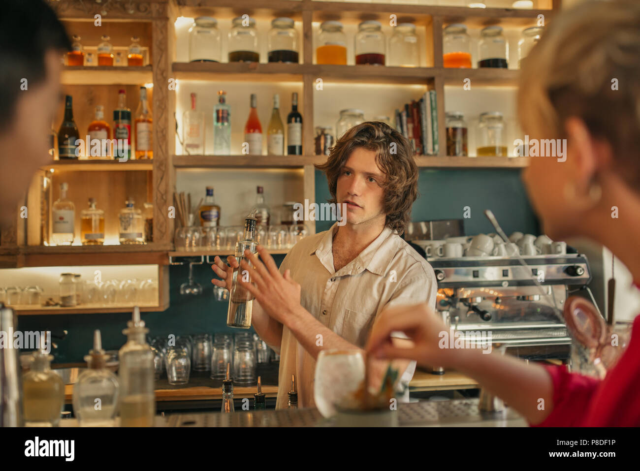 Barman prenant un verre des commandes des clients dans un bar branché Banque D'Images