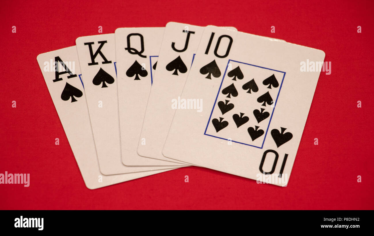 Main de poker Royal flush sur fond rouge. Banque D'Images