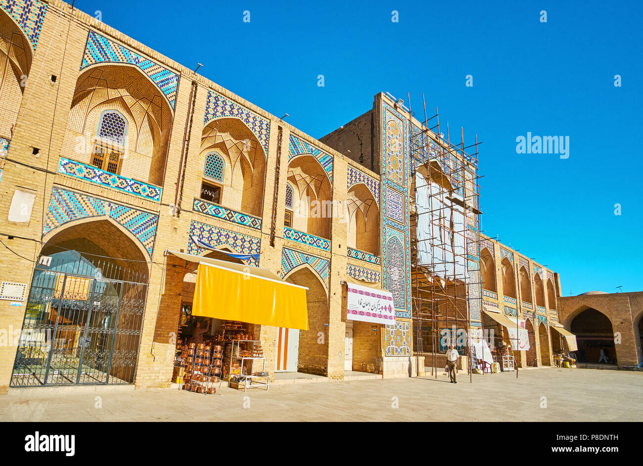 KERMAN, IRAN - 15 octobre 2017 : La façade de Ganjali Khan caravansérail avec des stands et des ateliers, sol carrelé iwan (portail) et niches voûtées traditiona - Banque D'Images