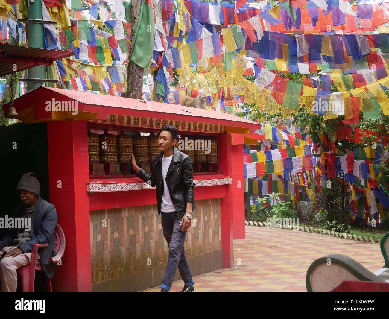 Un visiteur passe devant une rangée de roues de prière au temple Mahakal à Darjeeling, West Bengal, le 14 juin 2018. Banque D'Images