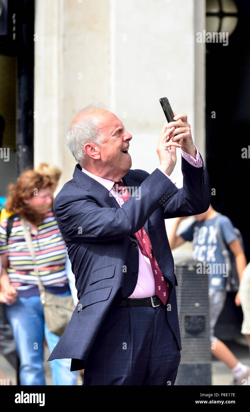 Gyles Brandreth - présentatrice TV, auteur et ancien député - de prendre une photo avec son téléphone à Westminster, Juillet 2018 Banque D'Images