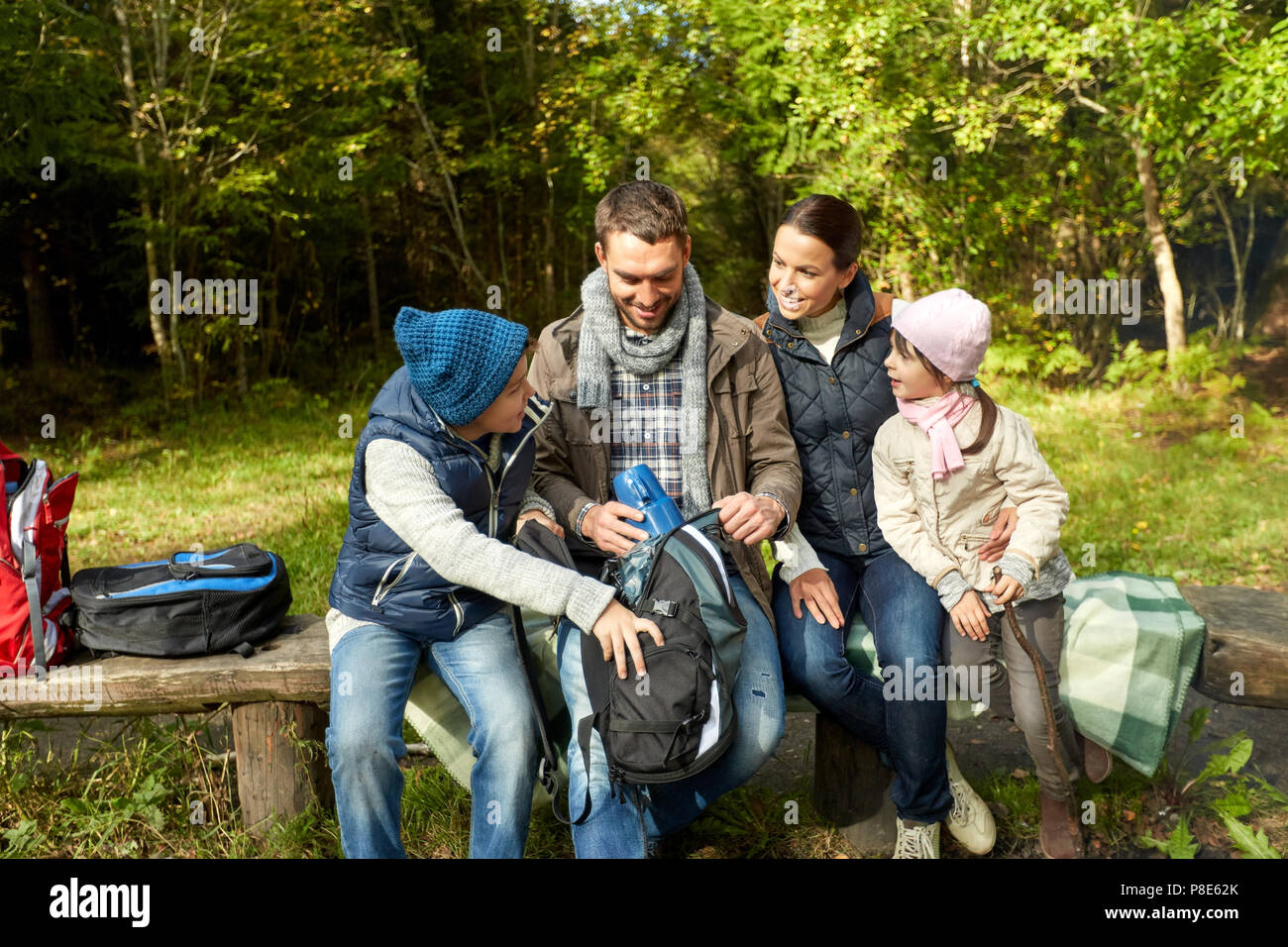 Famille heureuse avec sacs à dos et le thermos au camp Banque D'Images