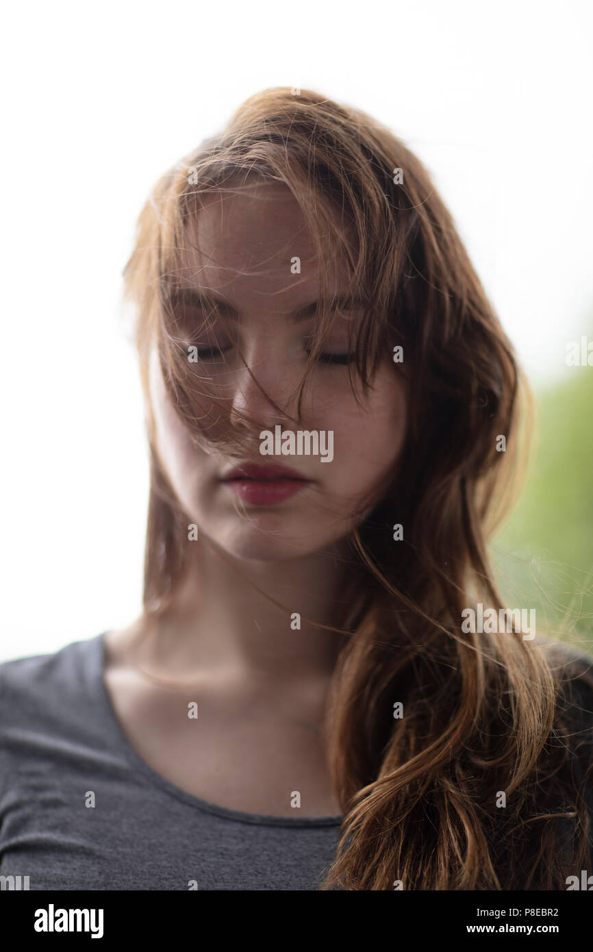 Portrait d'une jeune femme avec les yeux fermés et les cheveux tombant sur son visage. Close up. Focus sélectif. Banque D'Images