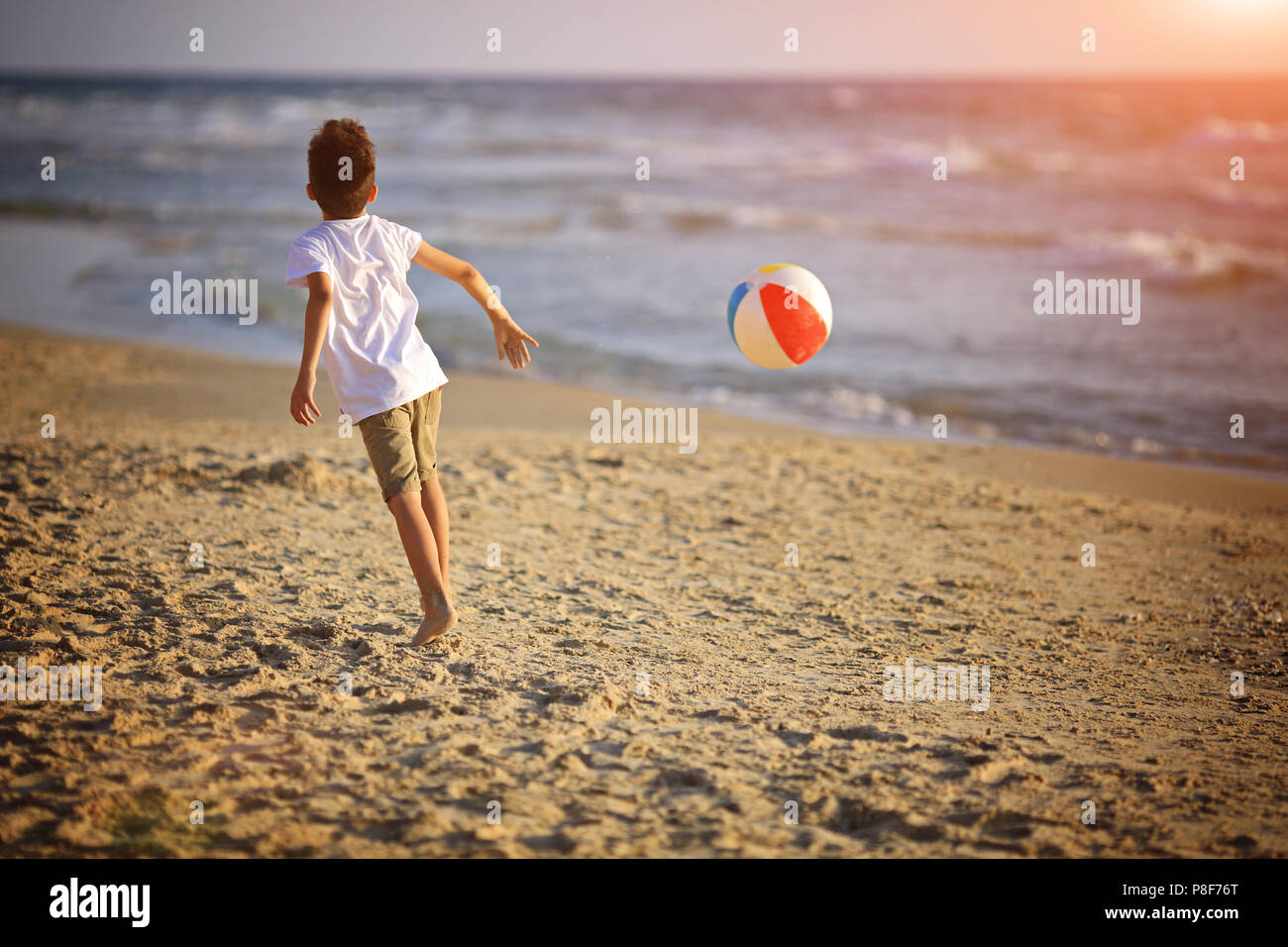 Boy Playing with ball on beach Banque D'Images