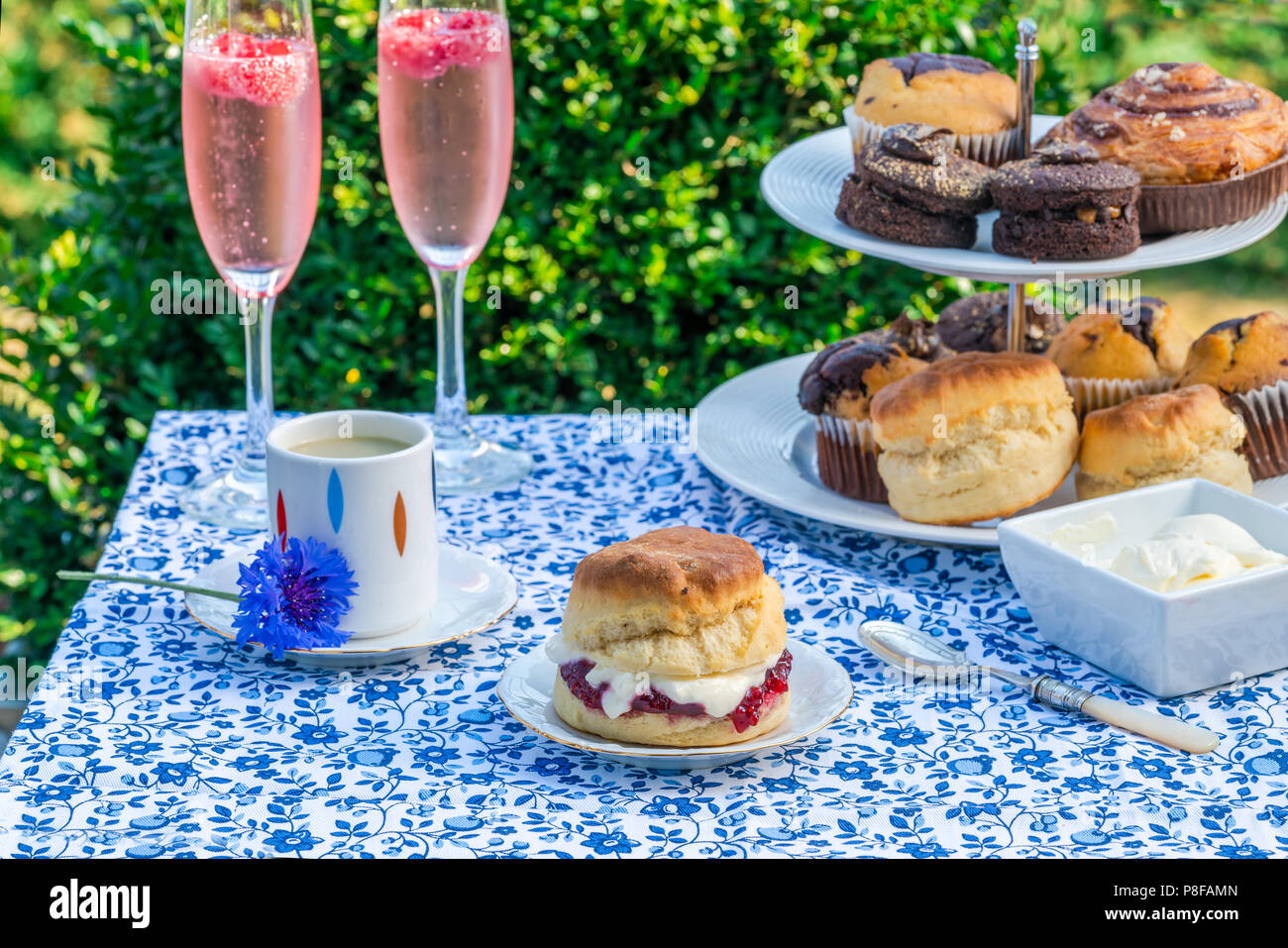 Apres Midi Du The Avec Des Gateaux Et Des Scones Anglais Traditionnel Avec De La Confiture De Fraise Et Creme Caillee Mis En Place Sur Une Table Dans Le Jardin Les Repas En