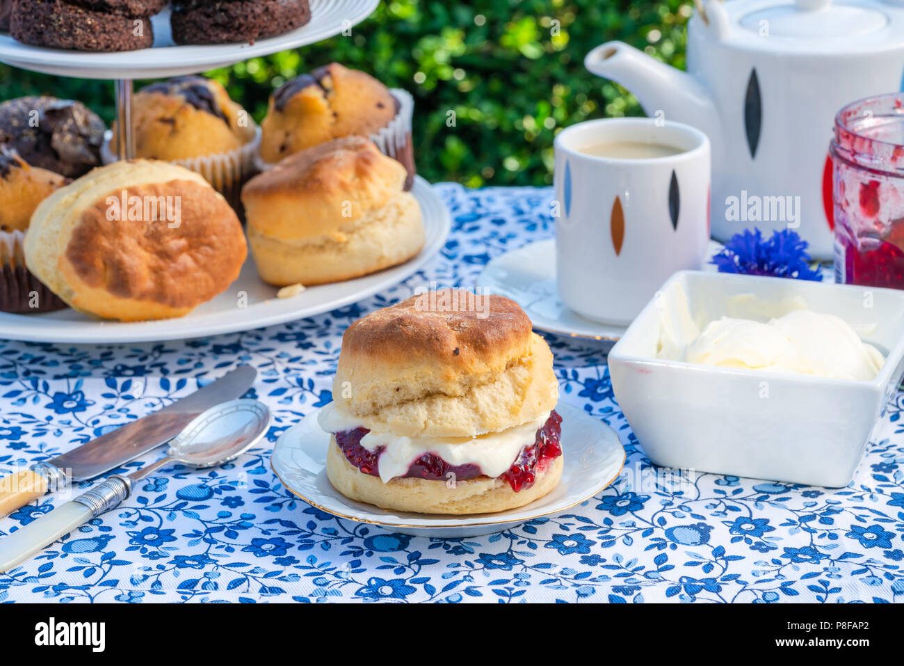Apres Midi Du The Avec Des Gateaux Et Des Scones Anglais Traditionnel Avec De La Confiture De Fraise Et Creme Caillee Mis En Place Sur Une Table Dans Le Jardin Les Repas En