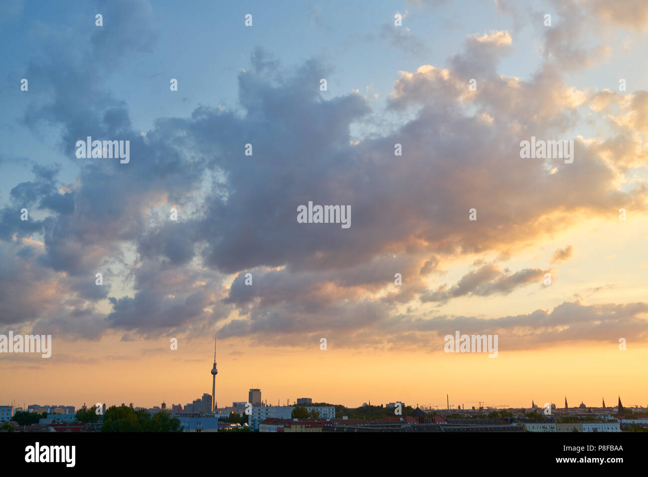 La ville de Berlin avec la tour de télévision et le coucher du soleil en face d'un ciel nuageux Banque D'Images