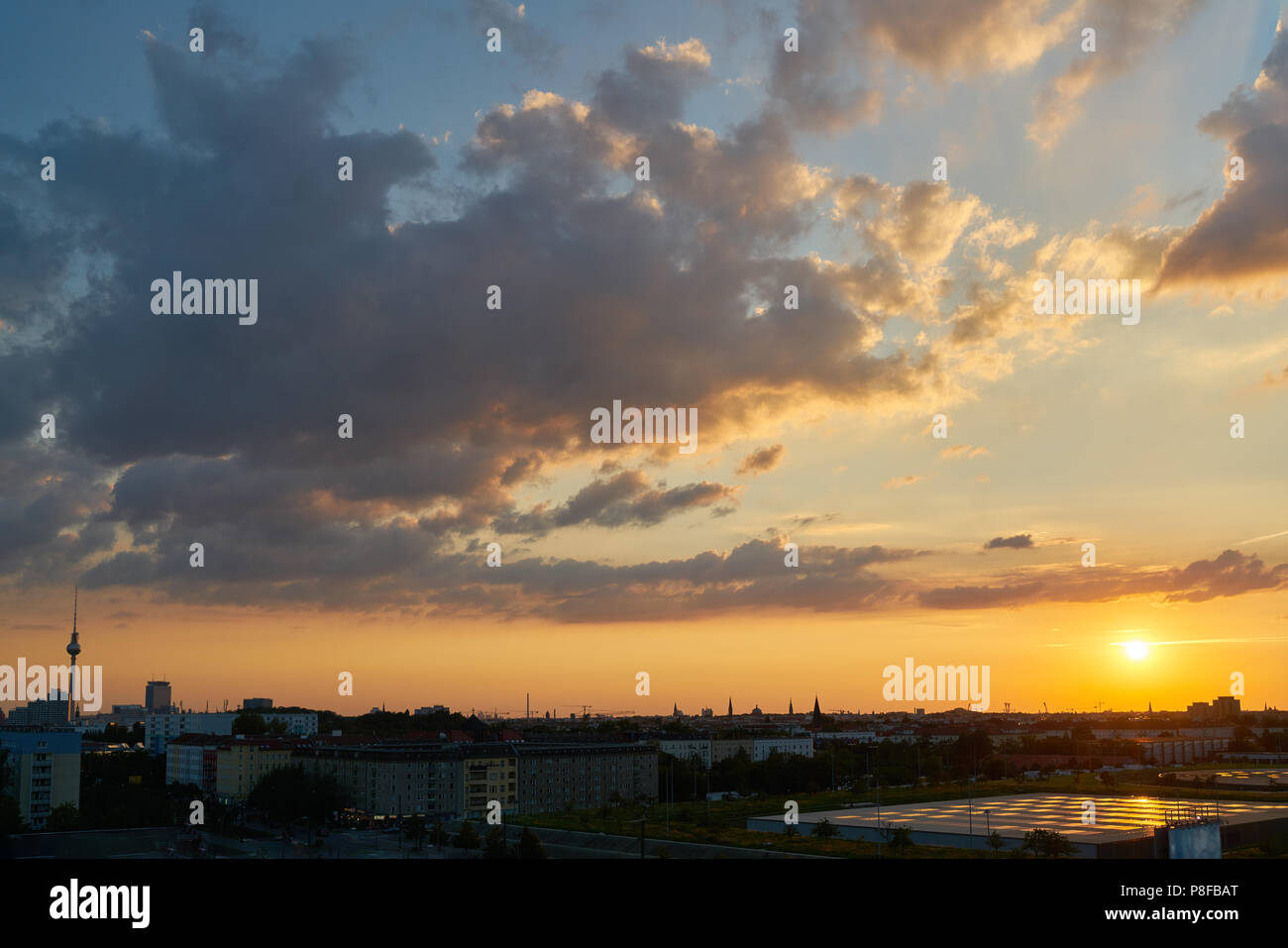 Coucher du soleil en face de nuages dans la ville de Berlin avec la tour de télévision en l'horizon Banque D'Images