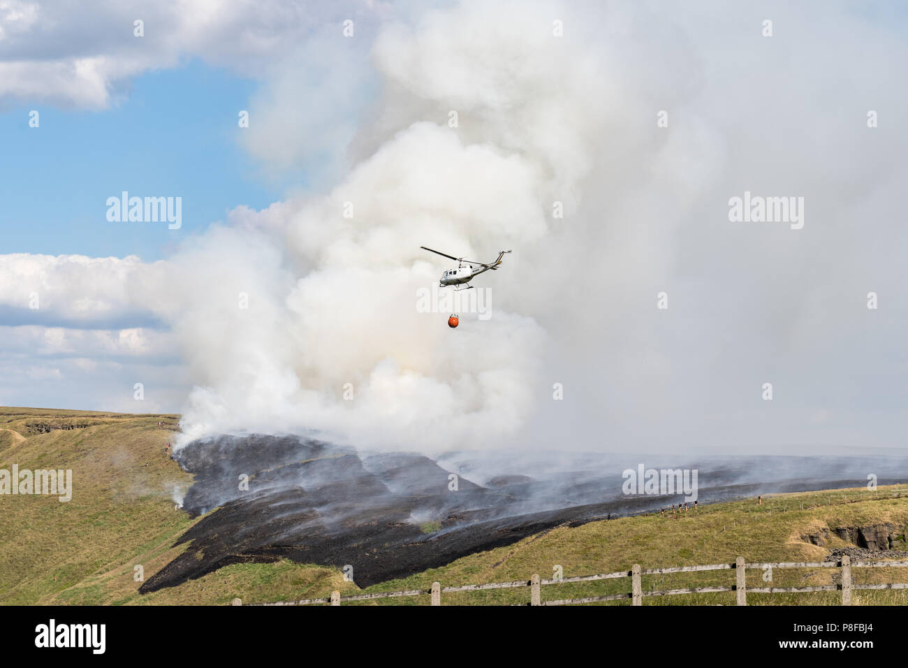 Hélicoptère qui goutte de l'eau sur le feu de moor Banque D'Images