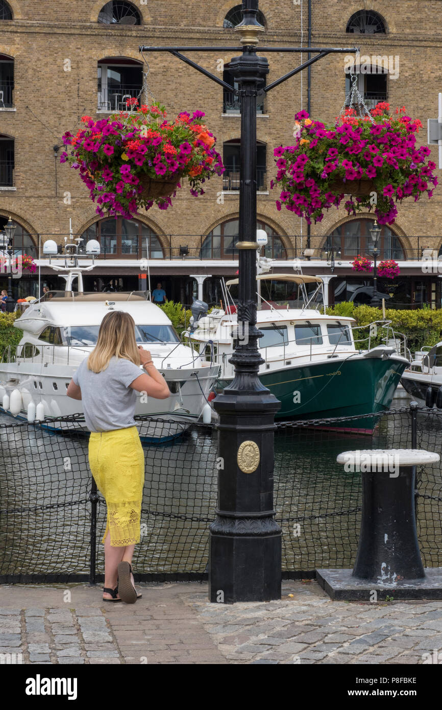 Woman on phone, St Katherine Docks marina, tamise, Londres, Angleterre, Royaume-Uni. Banque D'Images