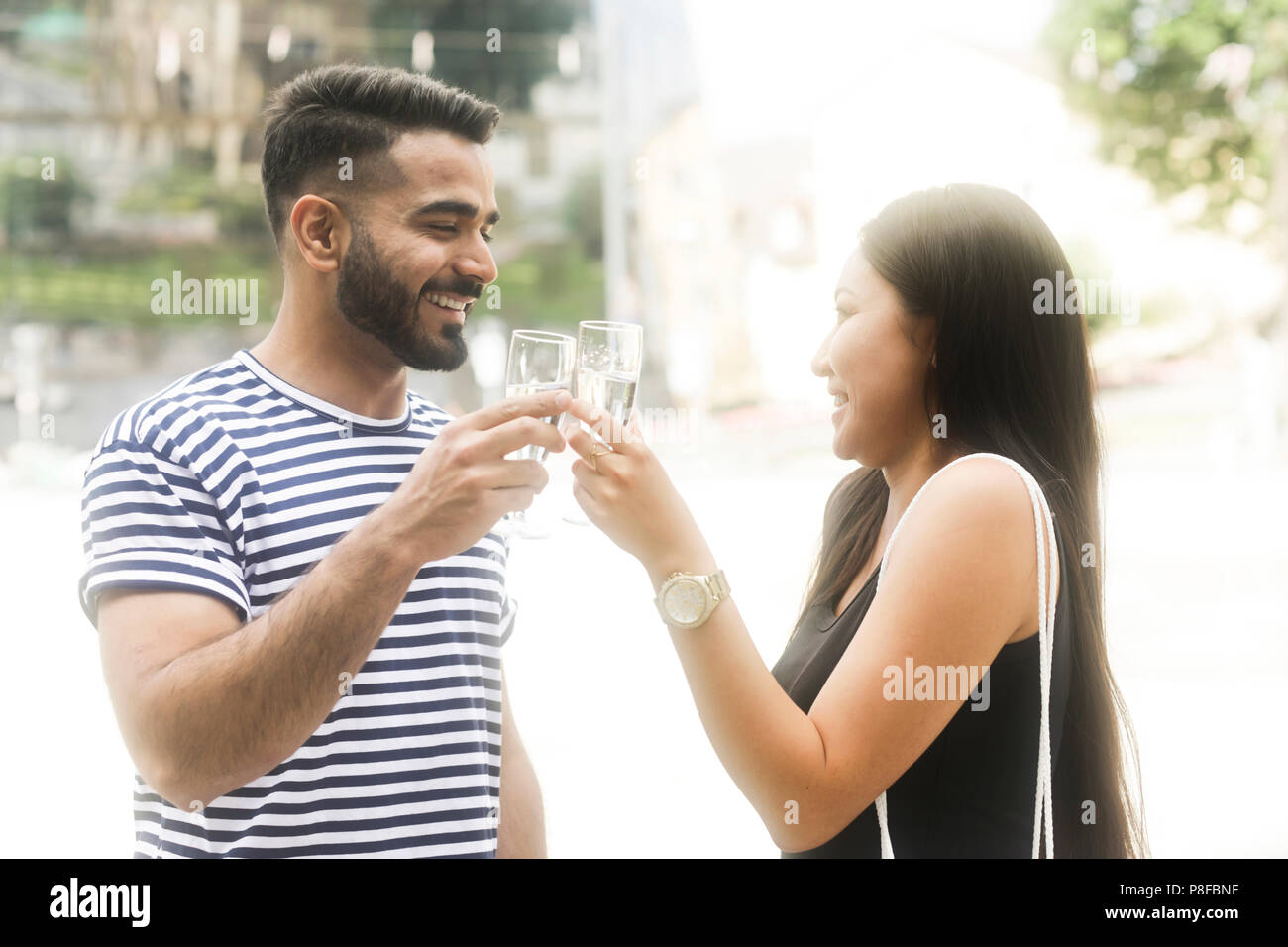 Couple standing par une fontaine d'eau faire un toast célébration Banque D'Images