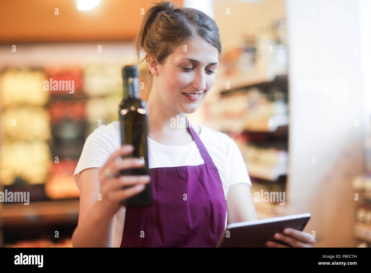 Supermarché shop assistant contrôle de produits en utilisant une tablette numérique Banque D'Images