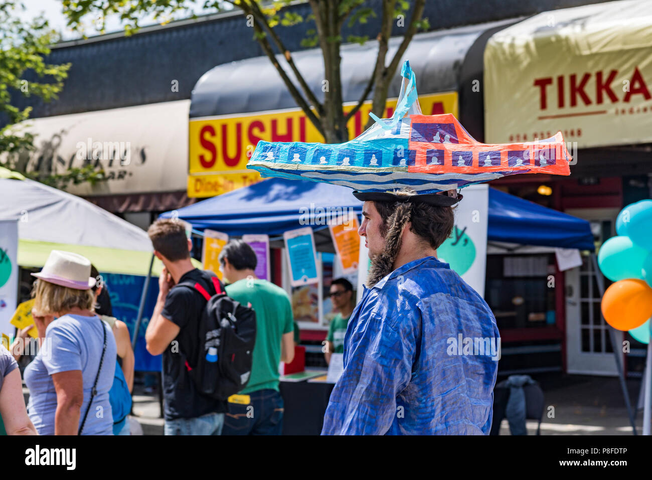 Homme avec papier mâché le Seabus hat, la Journée sans voiture, Commercial Drive, Vancouver, Colombie-Britannique, Canada. Banque D'Images