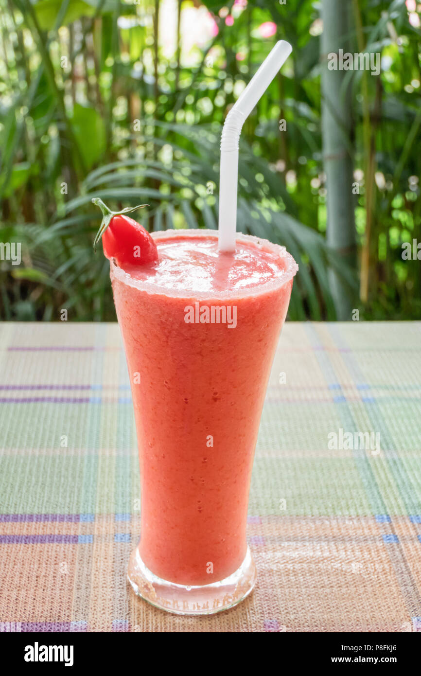 Smoothie sain dans un verre avec de la tomate sur un fond nature Banque D'Images