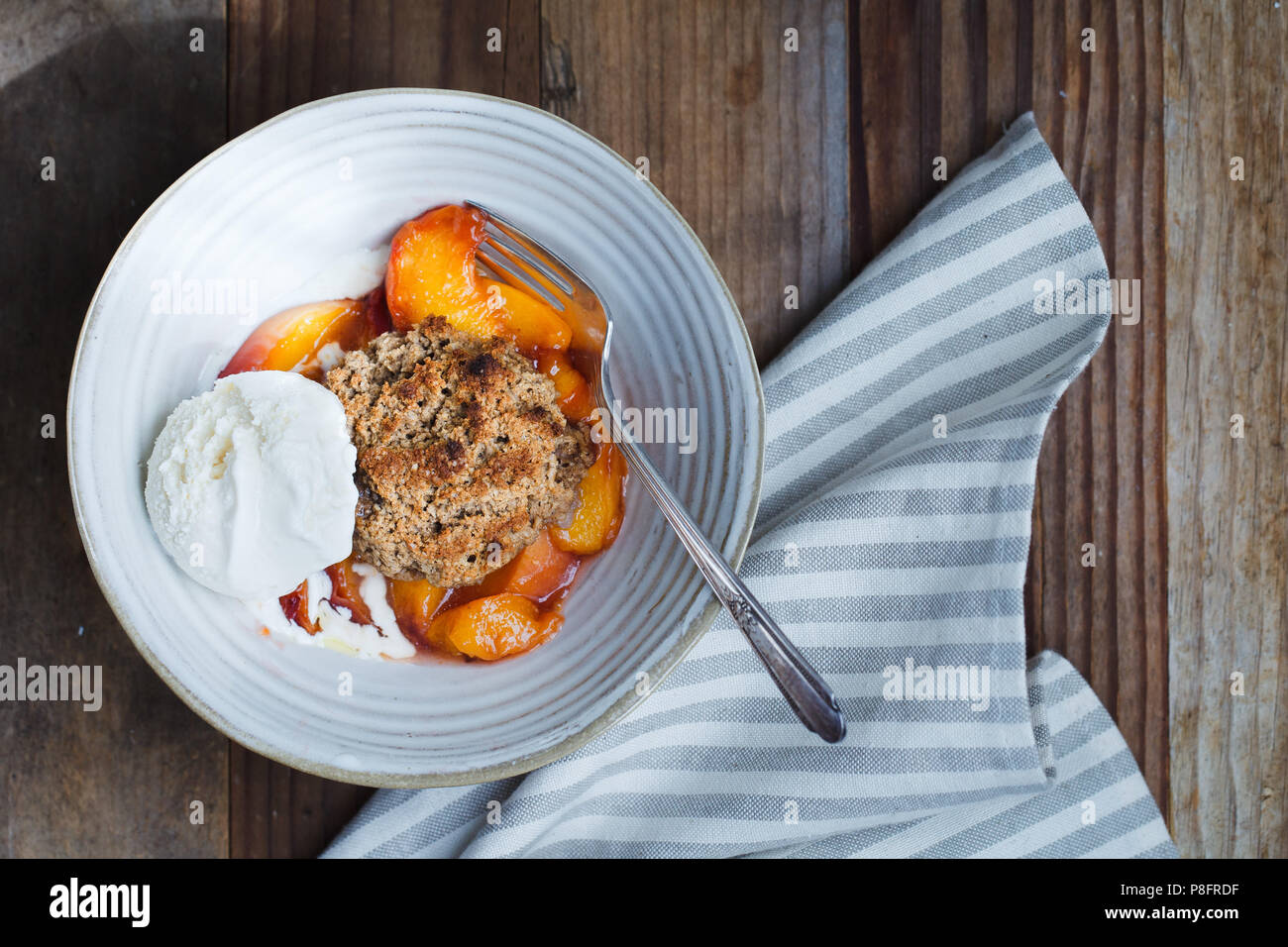 Peach cobbler dans un bol avec de la crème glacée Banque D'Images