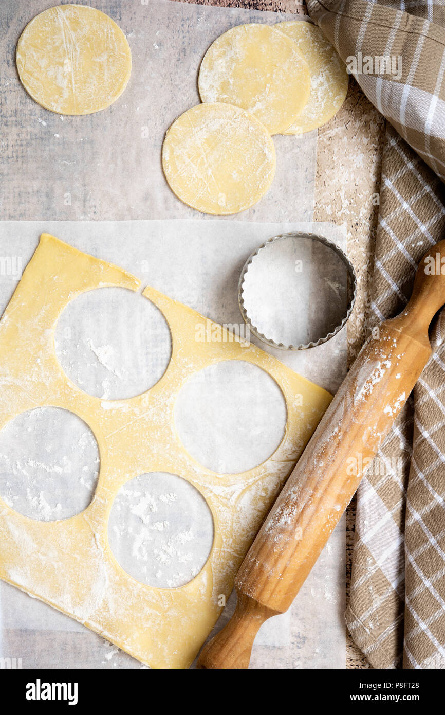 Les cercles de pâte avec un coupeur de biscuit et de rouleau à pâtisserie. Banque D'Images