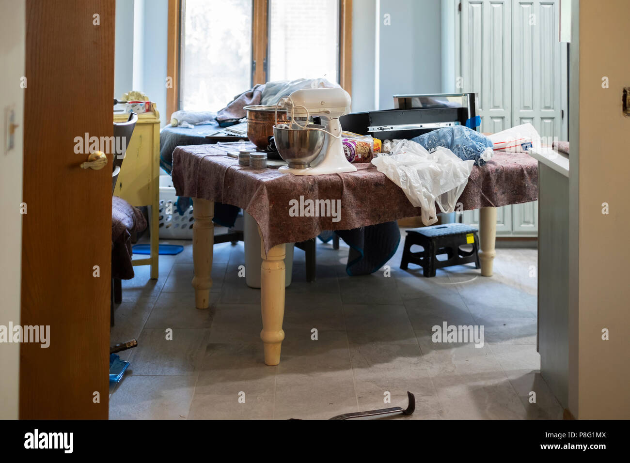 Une table de salle à manger couverts dans une couverture protectrice avec ménage pendant un transformer dans le Kansas, USA. Banque D'Images