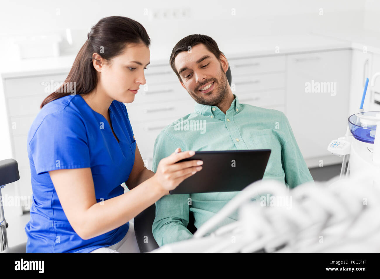 Dentiste et patient avec tablette pc à la clinique Banque D'Images