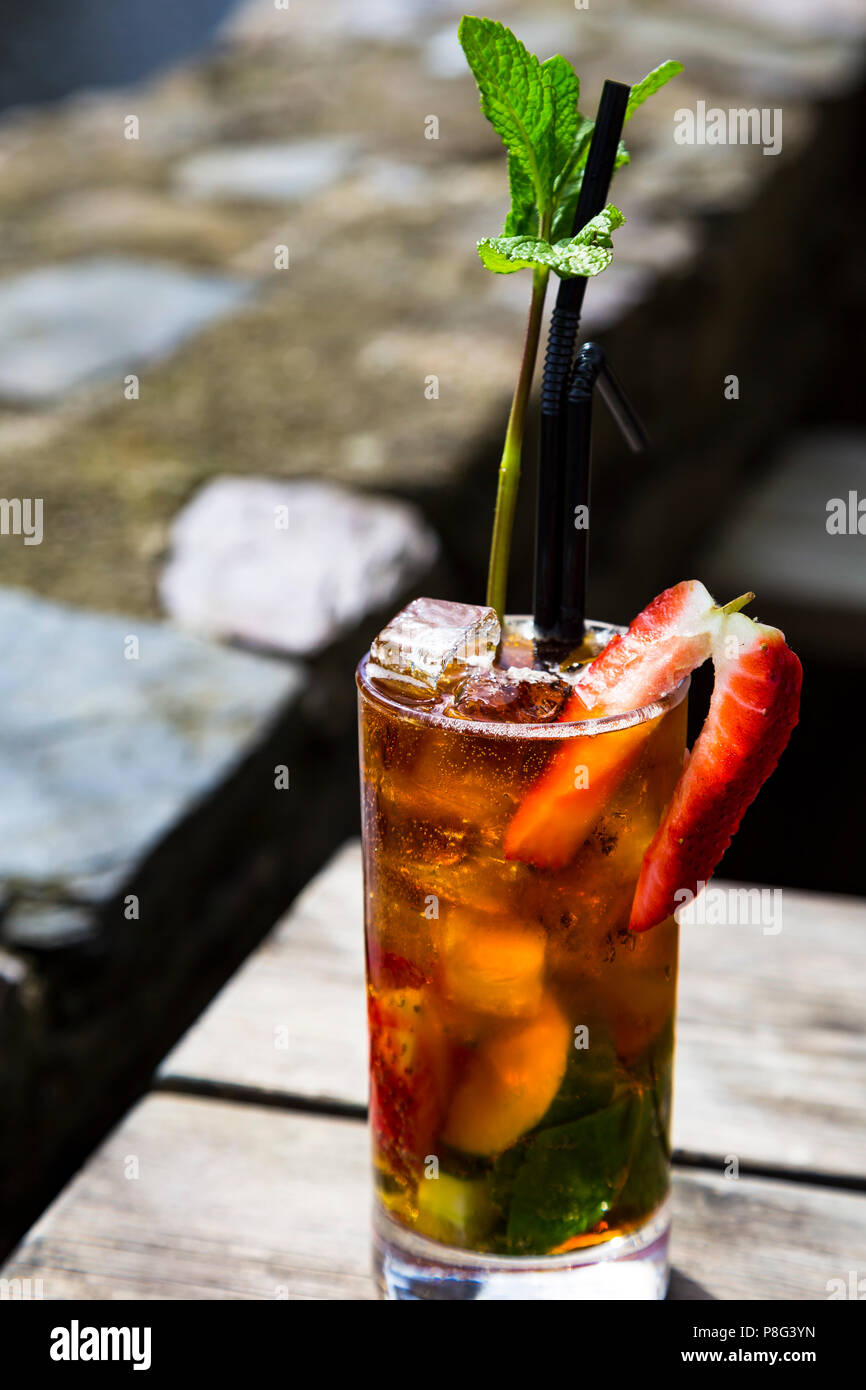 Un Pimm's dans un verre sur une table en bois - un brin de menthe comme un arbre Banque D'Images