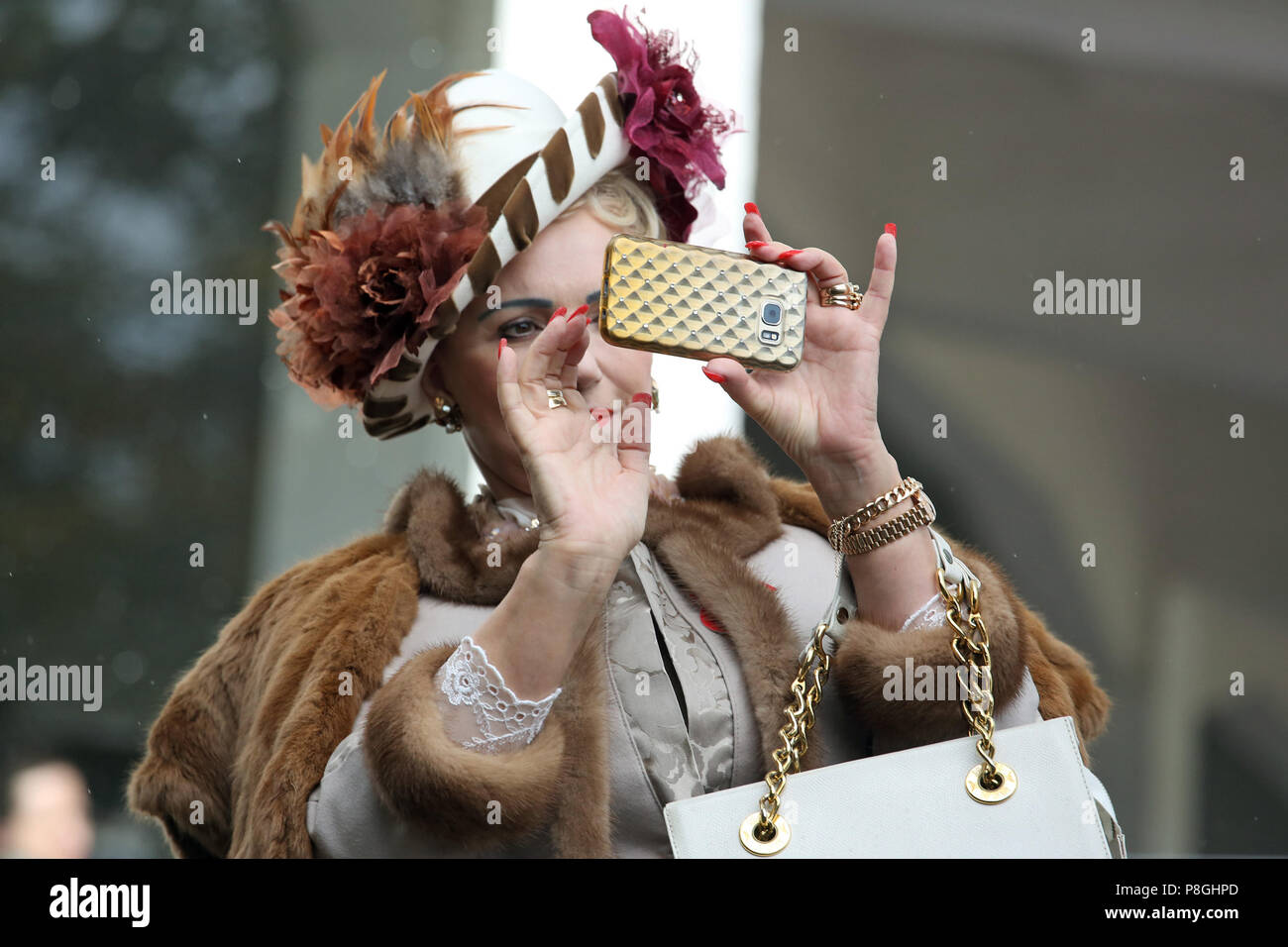 Berlin, Allemagne, élégamment vêtue femme prend une photo avec son smartphone Banque D'Images