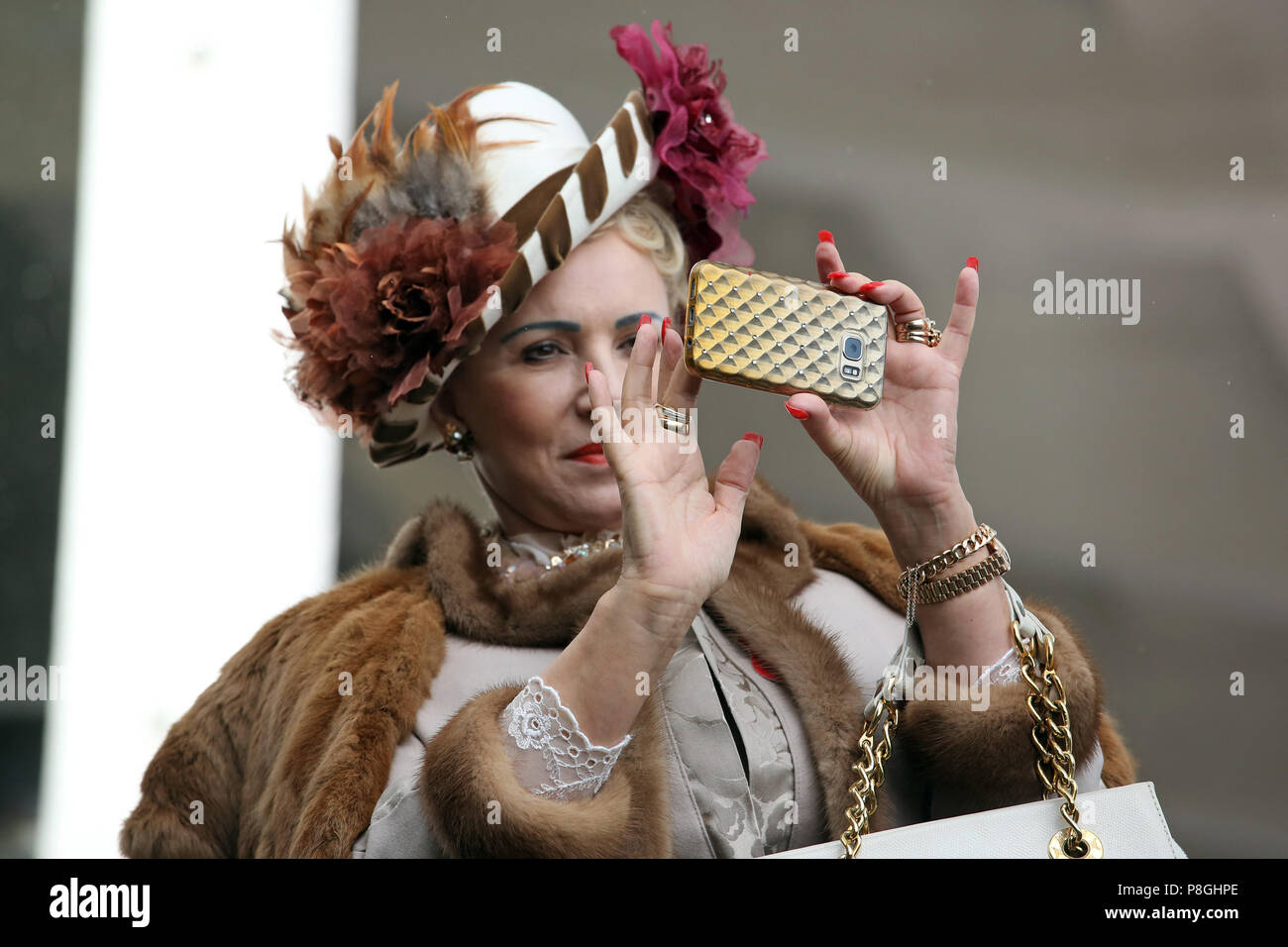 Berlin, Allemagne, élégamment vêtue femme prend une photo avec son smartphone Banque D'Images