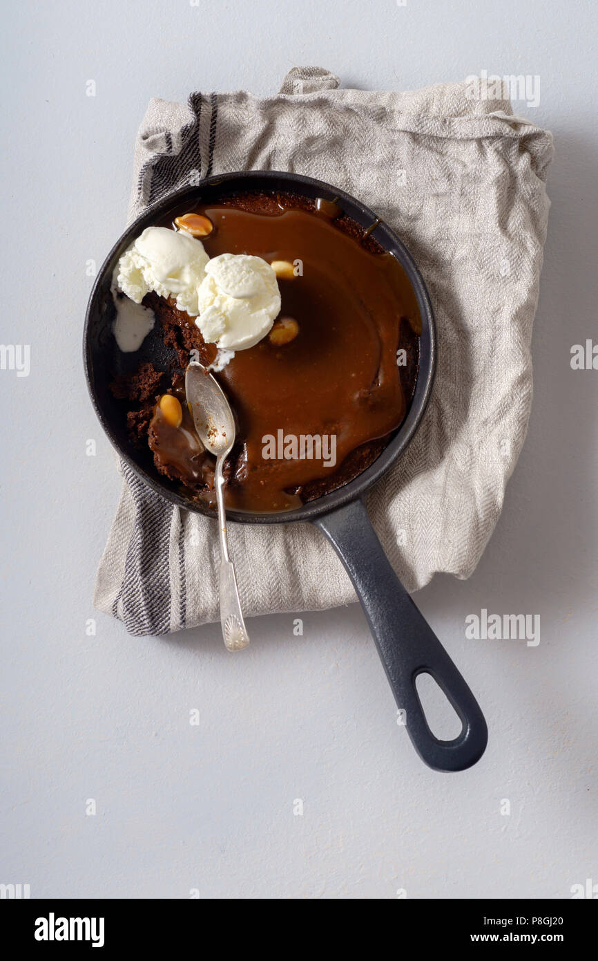 Brownie dans une poêle avec une boule de glace à la vanille, caramel au  beurre salé et des cacahuètes grillées Photo Stock - Alamy
