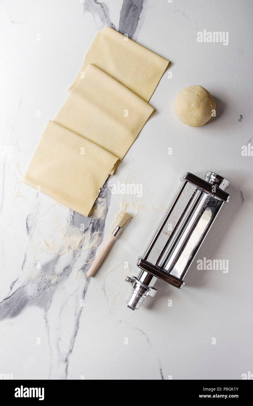 Pâte roulée pour lasagne italienne maison Pâtes alimentaires non cuites de  machine à pâtes bouilloire avec farine de semoule sur le marbre blanc  texture background. Mise à plat Photo Stock - Alamy