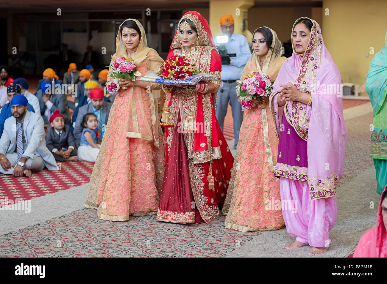 Une belle épouse et ses accompagnateurs entrer dans le temple à sa cérémonie de mariage dans le temple à la Sikh Society à Richmond Hill, Queens, New York City Banque D'Images