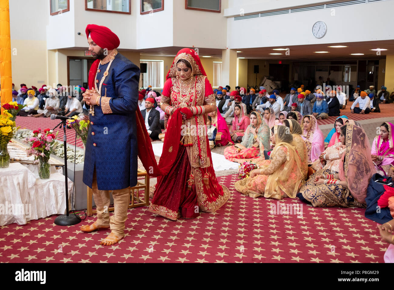 Une jeune mariée et se toilettent circle l'autel lors d'une cérémonie de mariage dans le temple à la Sikh Society à Richmond Hill, Queens, New York. Banque D'Images