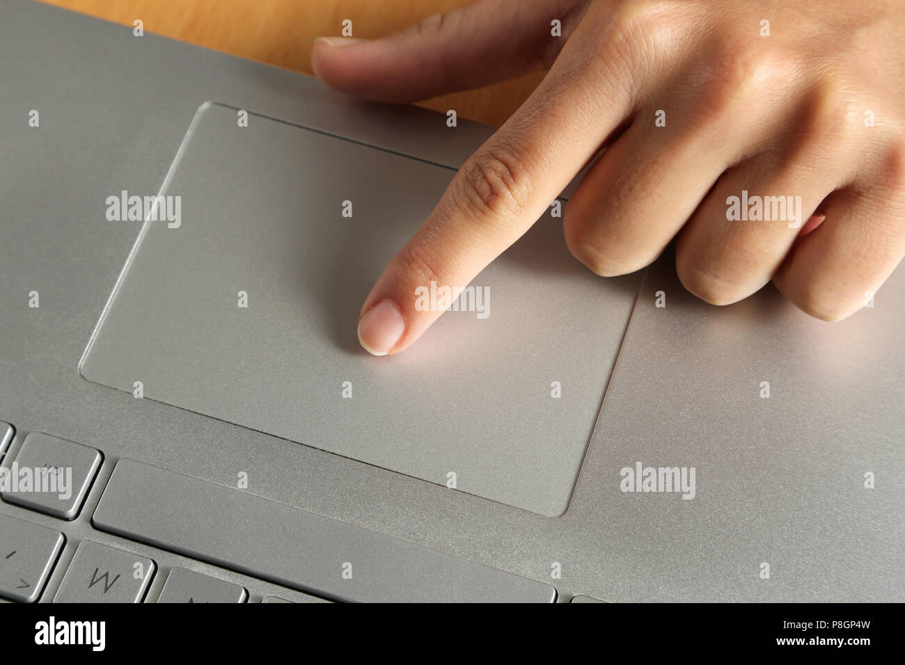 Close-up o une femme le doigt sur le touchpad d'un ordinateur portable dans le bureau. Banque D'Images