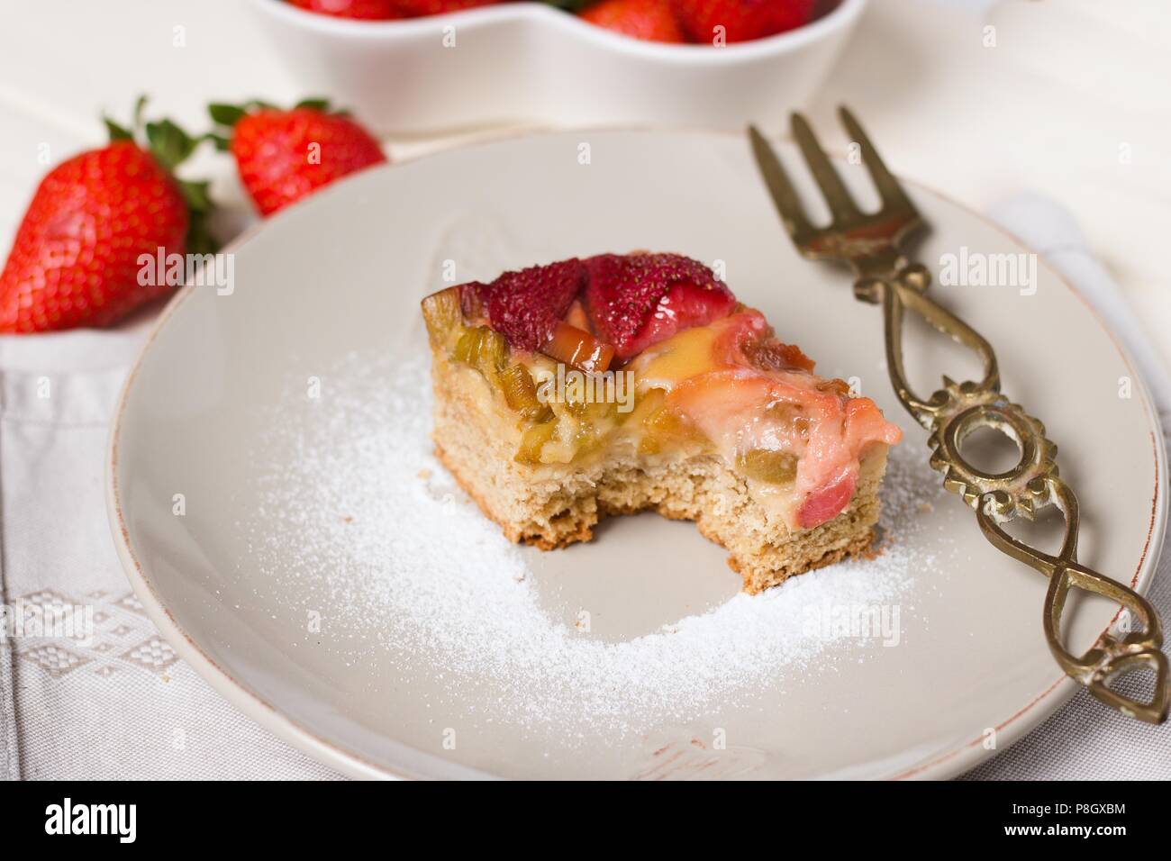 Servant de la rhubarbe et fraises gâteau avec une piece manquante, clairement visé Banque D'Images