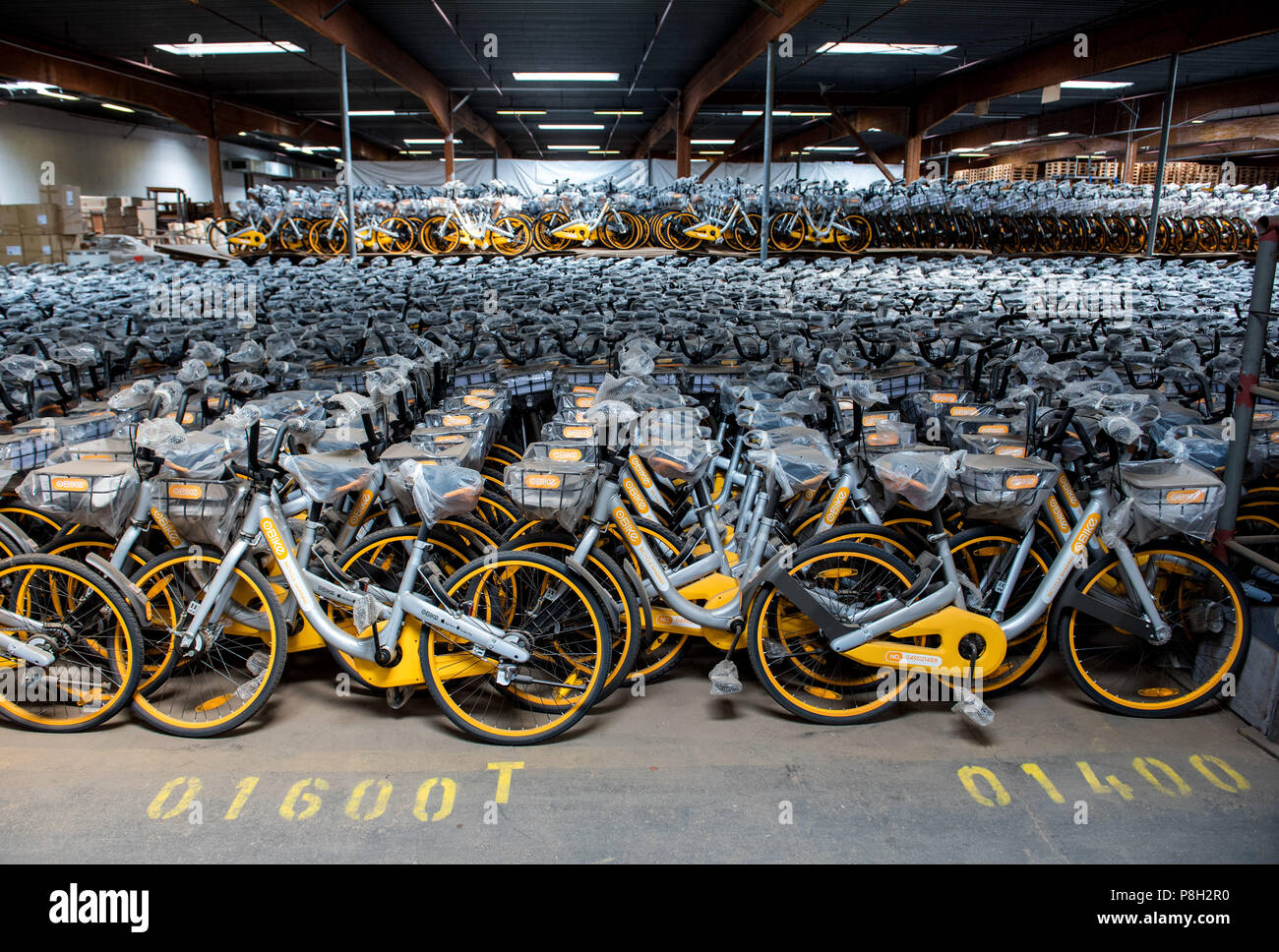 Barsbuettel, Allemagne. 10 juillet, 2018. Autour de 10 000 vélos à louer du prestataire Obike stand à côté de l'autre dans un dépôt. Dans plusieurs villes allemandes, les problèmes avec le jaune d'argent à louer des vélos de Obike sont de plus en plus. Crédit : Daniel Bockwoldt/dpa/Alamy Live News Banque D'Images