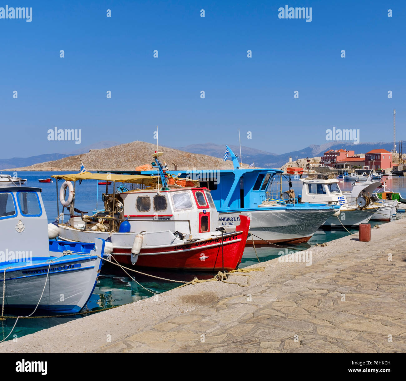 Bateau rouge au milieu d'une ligne de bateaux dans le port de Halki. Banque D'Images