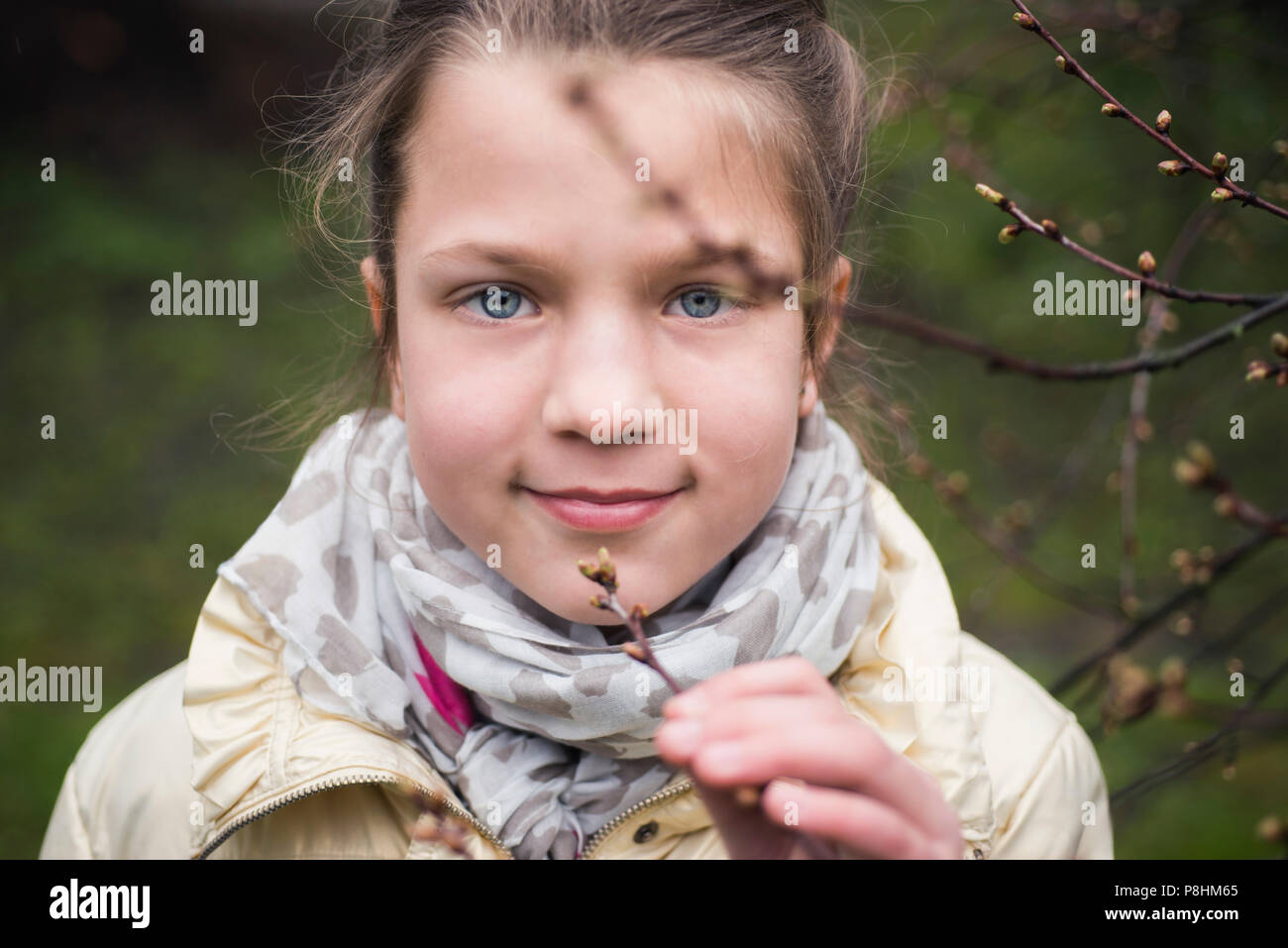 Fille respire en odeur de bourgeons d'arbres au début de printemps Banque D'Images