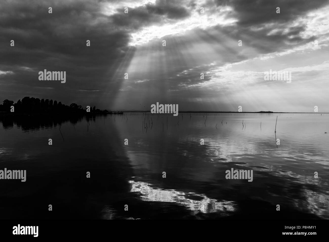 Parfaitement symétrique et vue spectaculaire d'un lac, avec des nuages, le ciel et les rayons du soleil reflétant sur l'eau Banque D'Images