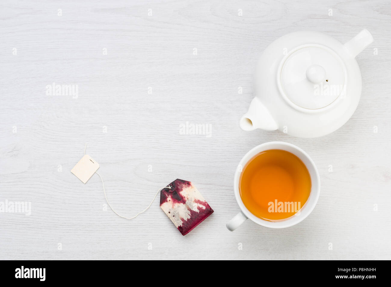 Théière avec tasse de thé et un sachet de thé sur la table Banque D'Images