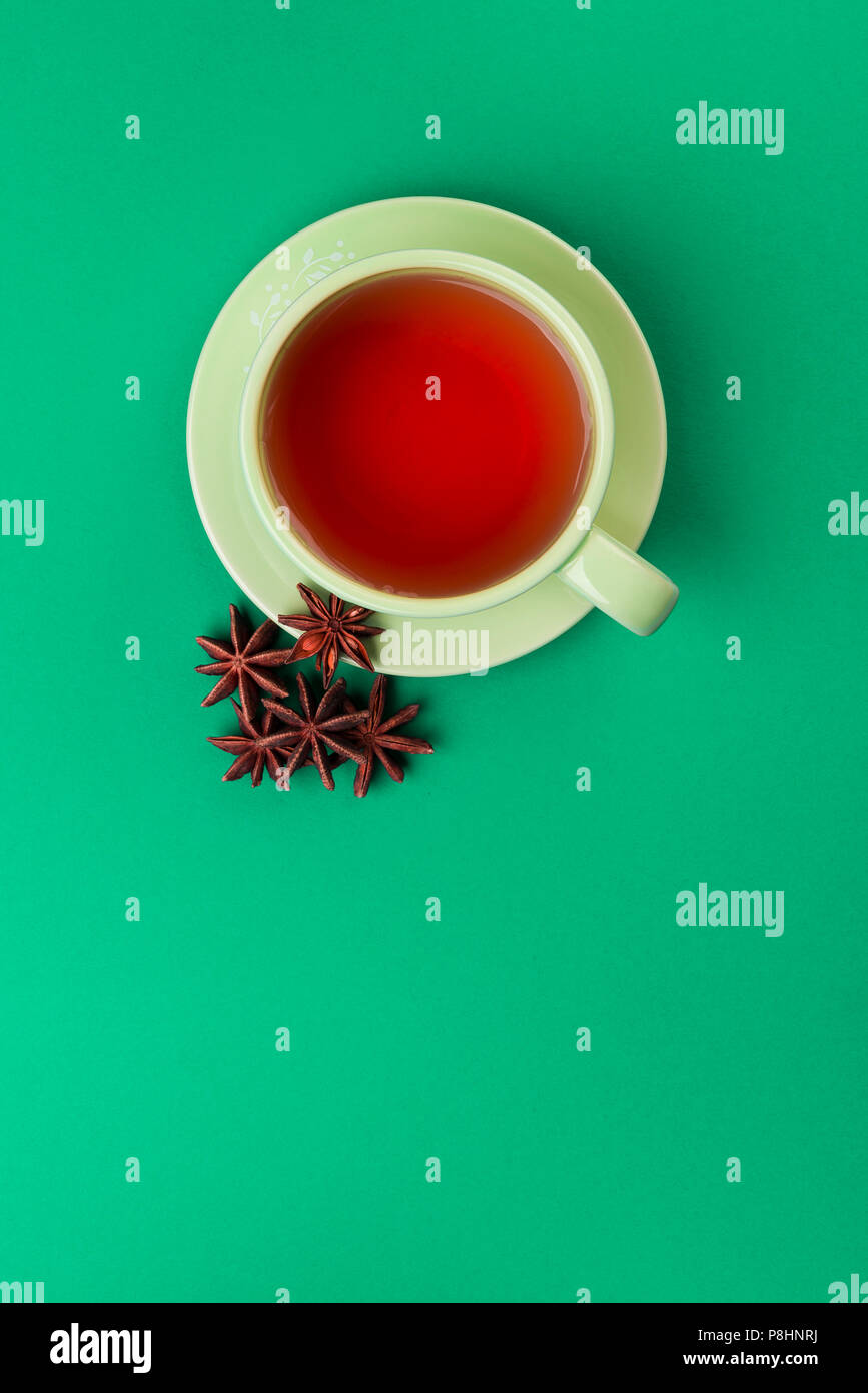 Tasse de thé vert avec de l'anis étoile sur une nappe verte. Banque D'Images