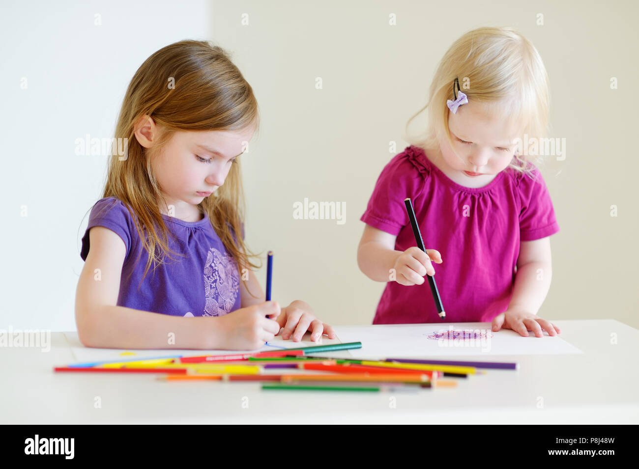 Deux sœurs mignon petit dessin avec des crayons de couleur dans une