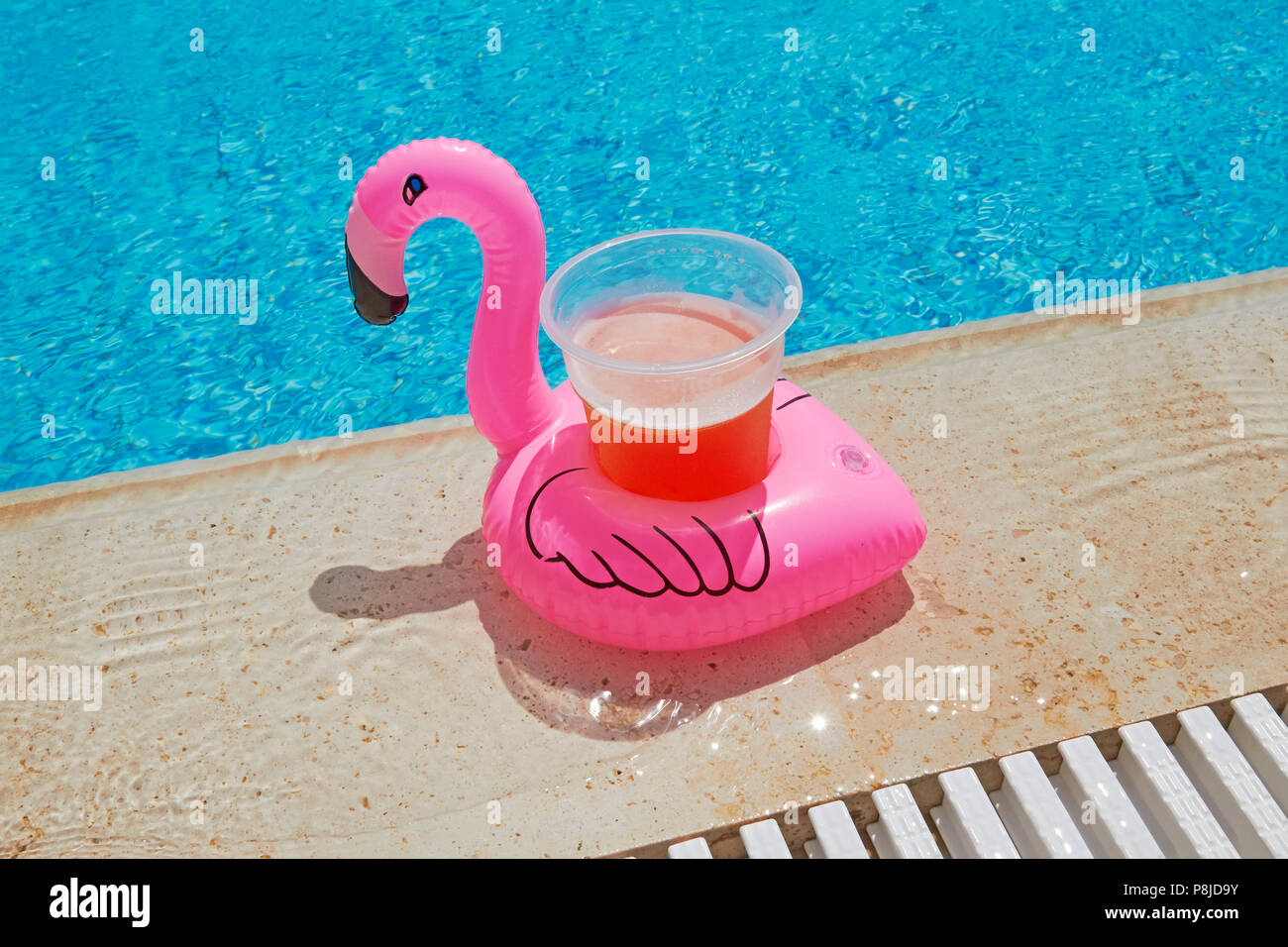 Porte-verre flamingo flotteur avec de la bière dans un pool party Banque D'Images