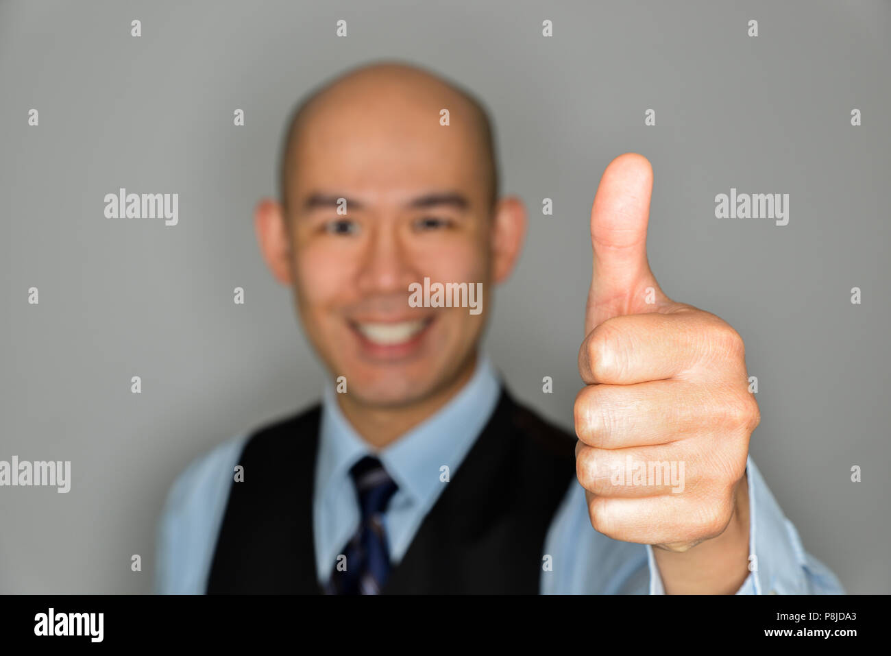 Homme d'affaires trouble clair offrant Thumbs Up et sourire - Notion de réussite, aimant et bon travail Banque D'Images