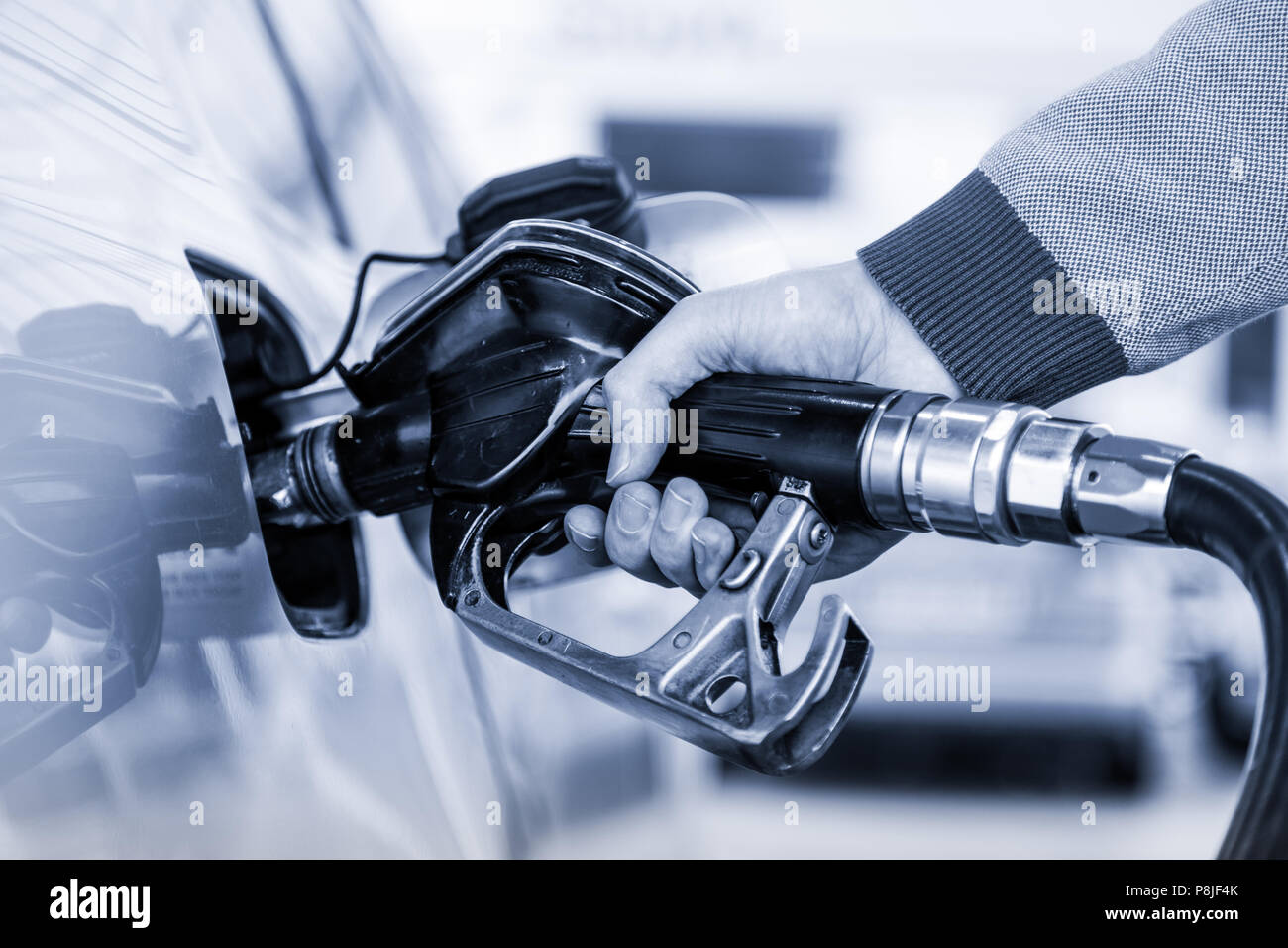 Gros plan du mans de pompage de carburant de l'essence à la main en voiture à la station d'essence. Banque D'Images