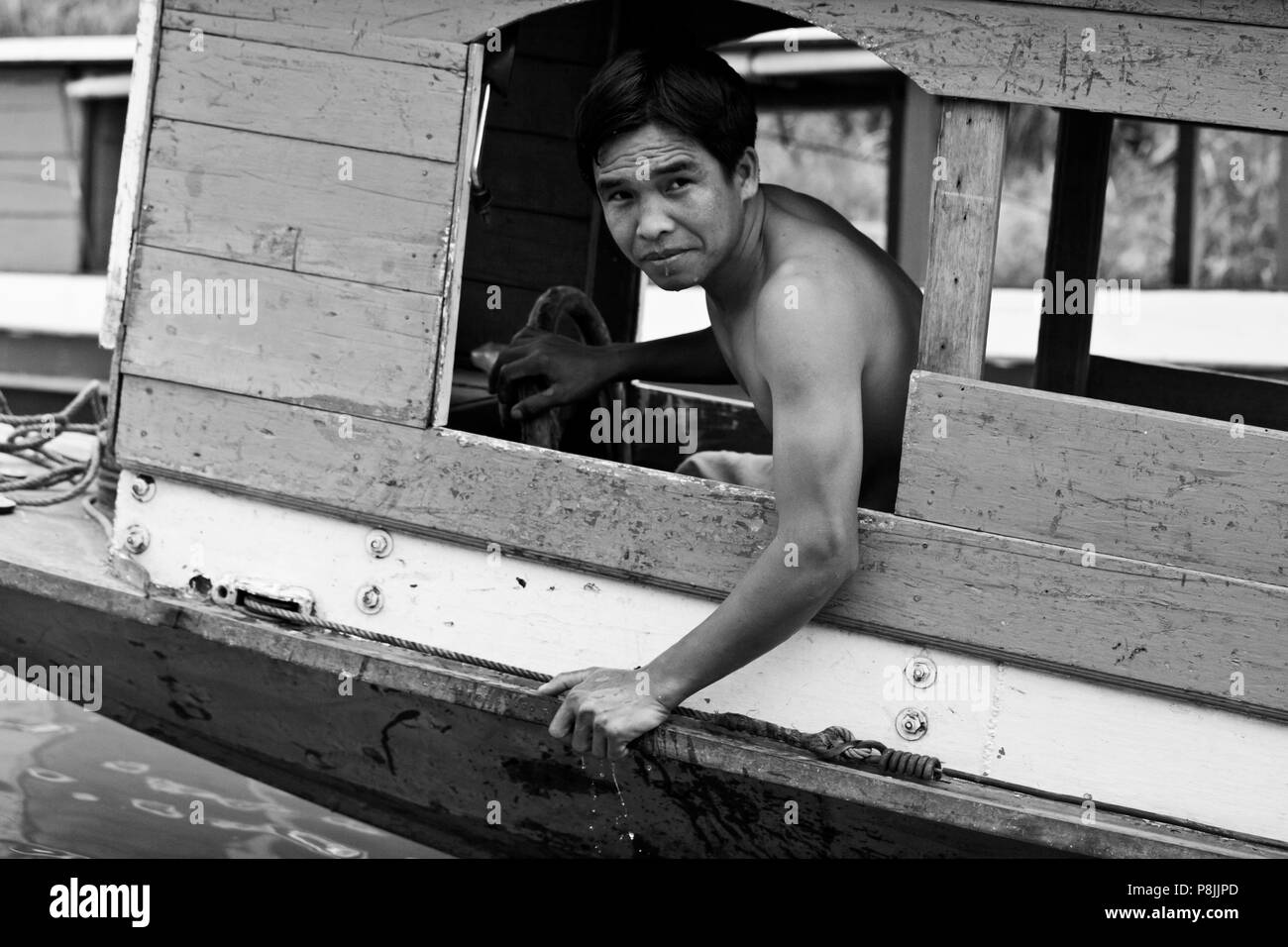 Homme laotien conduit un bateau sur le Mékong, Luang Prabang, Laos Banque D'Images