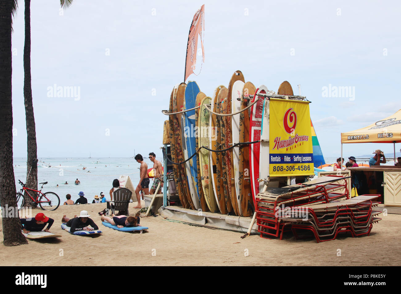 Surfboards disponible pour location touristique par Hawaiian Océans Société de location de voitures. À gauche un instructeur enseigne sur la plage de surf. La plage de Waikiki, Waikiki, Banque D'Images