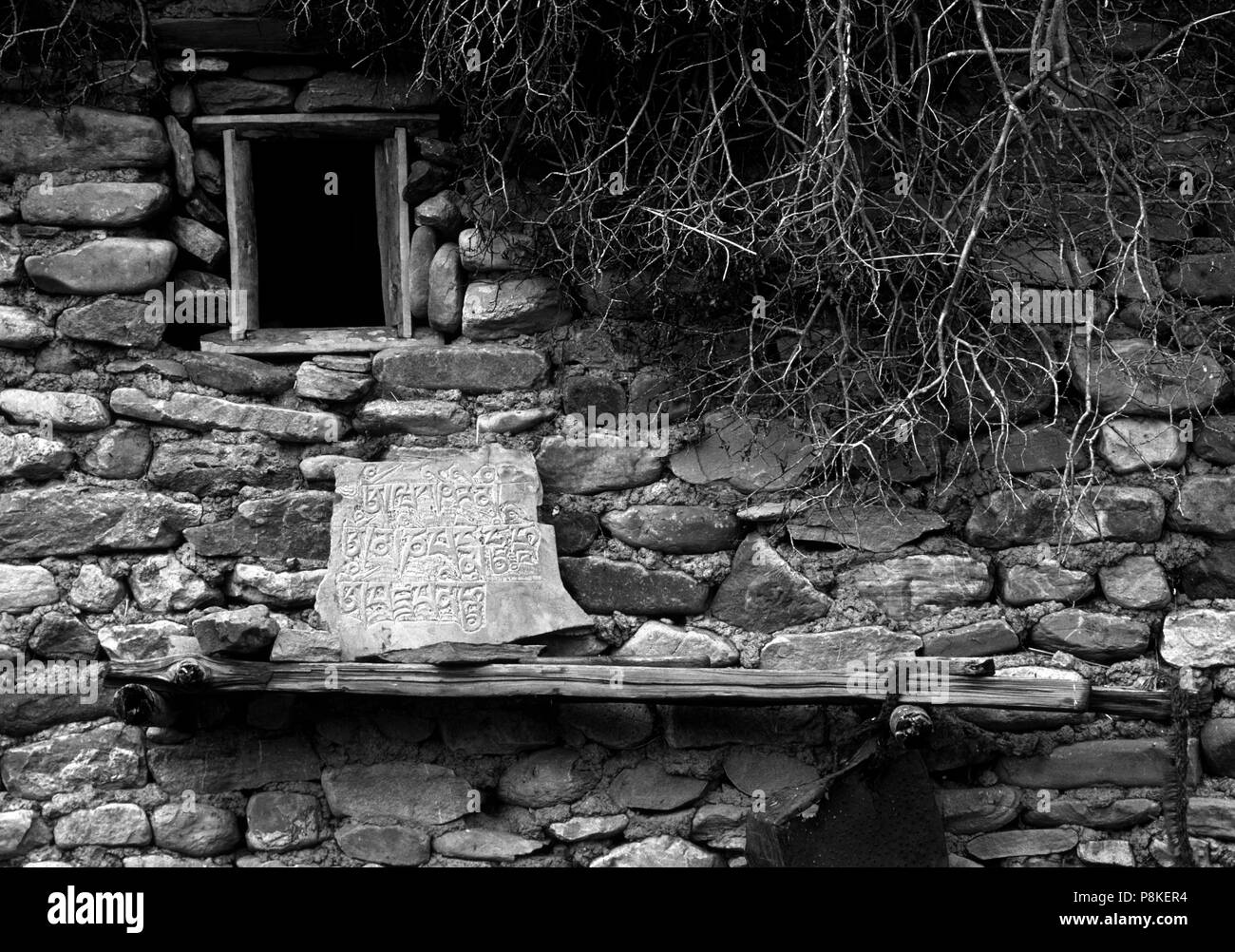 La pierre et la boue DOLPO maison avec une pierre sculptée Bouddhiste Tibétain MANI avec symboles dans la vallée de la TARAP DOLPO N - DISTRICT, NÉPAL Banque D'Images