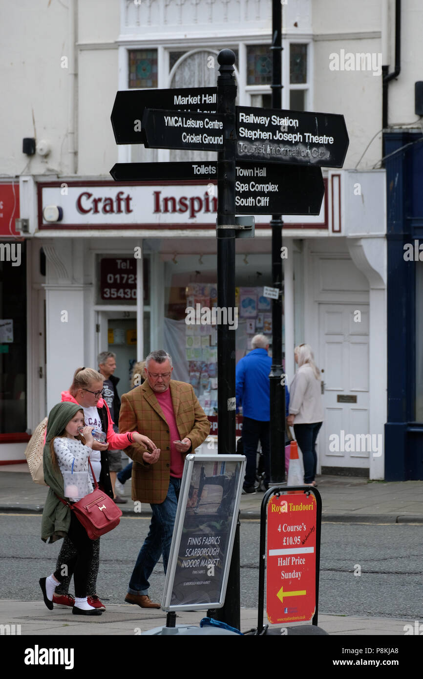 Shoppers marcher sous direction poster dans la ville du Yorkshire du Nord holiday resort de Scarborough,UK Banque D'Images