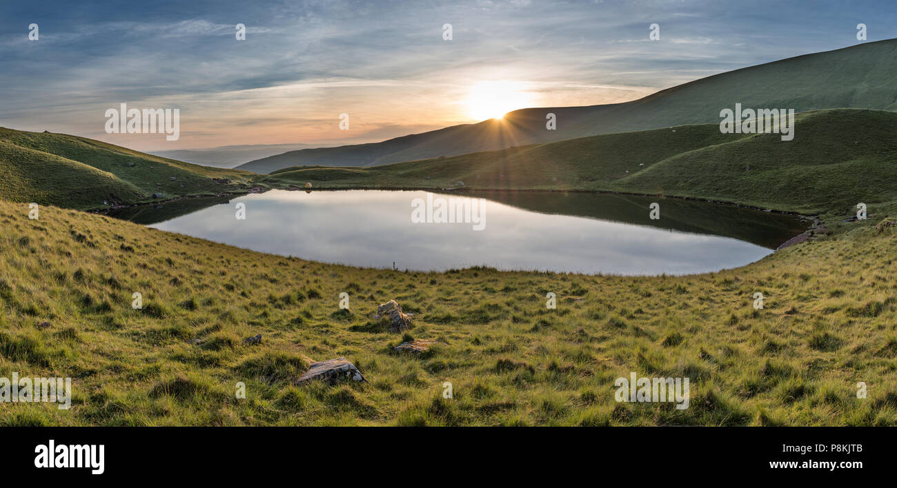 Bel été lever du soleil paysage par Llyn Cwm Llwch Lake dans le Parc National des Brecon Beacons avec camping sauvage Banque D'Images