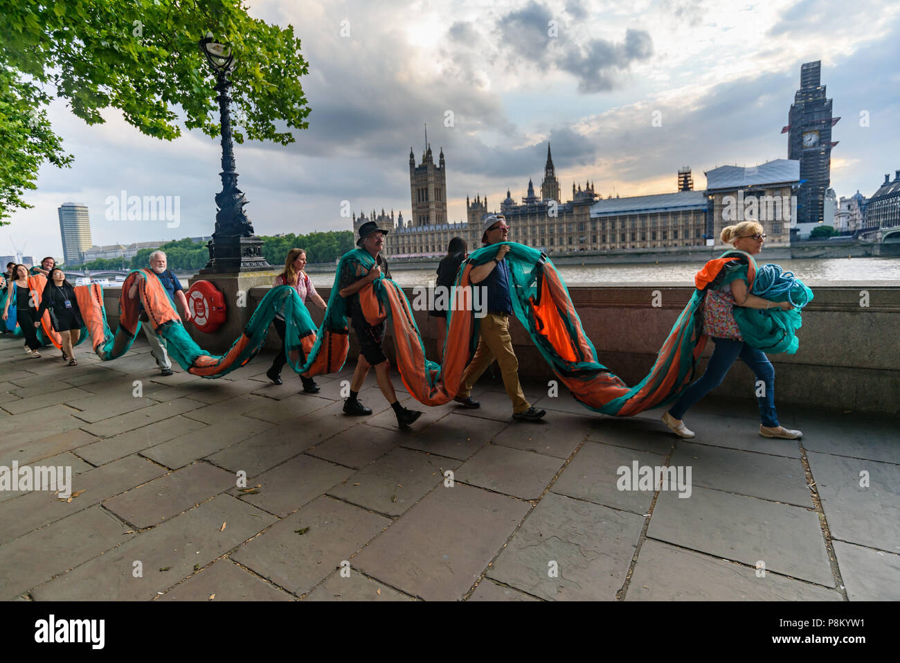 Londres, Royaume-Uni. 12 juillet 2018. Les militants climatiques portent une bannière géante de 100 mètres de longueur le long de la berge de la Tamise en face de la Chambre du Parlement où ils vont à l'afficher à l'occasion de la visite d'Atout au Royaume-Uni. La bannière a porté le message 'TRUMP : génocide climatique" en lettres orange fluorescent autour de 15m de haut. Ils disent qu'il est ignorant délibérément la science sur le changement climatique et menace l'existence même de la vie humaine sur terre en sapant si ce n'est pas renverser les nous et les efforts mondiaux pour lutter contre la plus grande menace que l'humanité fait face aujourd'hui, la déstabilisation catastrophique de glob Banque D'Images