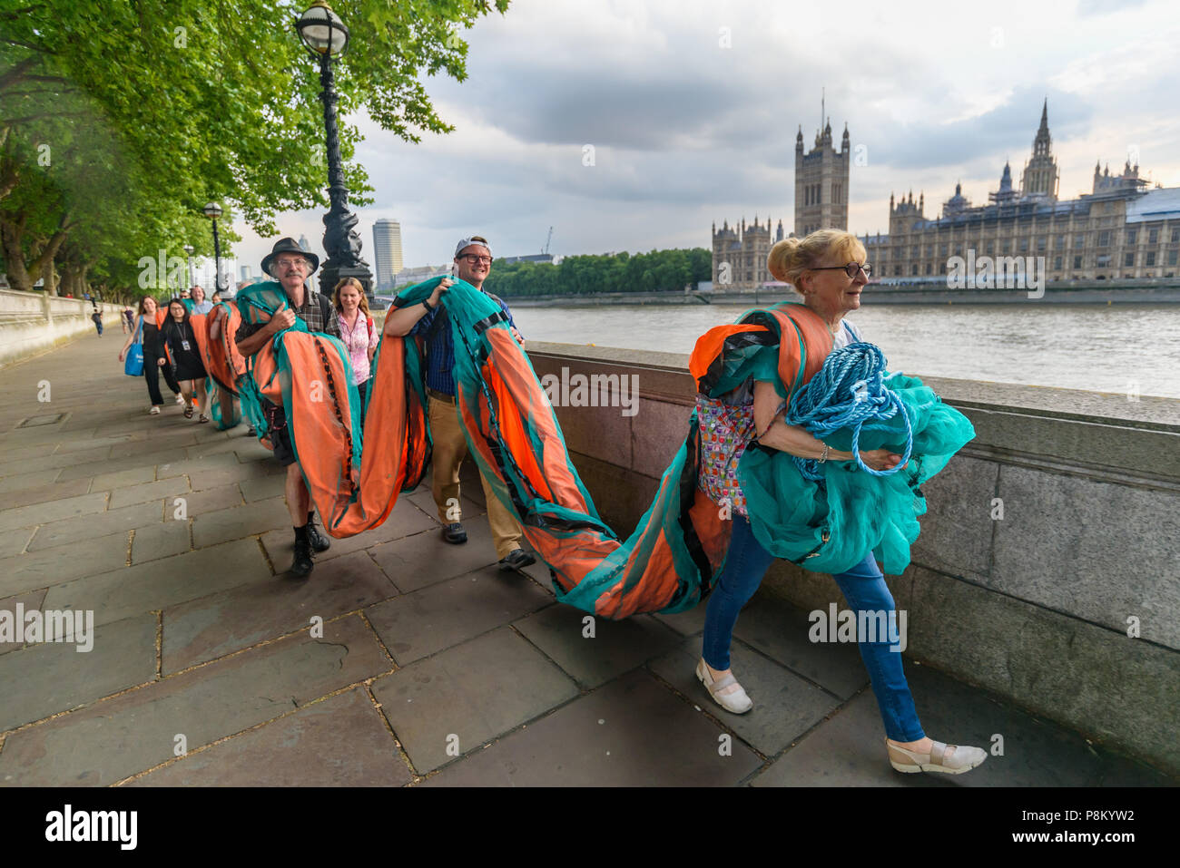 Londres, Royaume-Uni. 12 juillet 2018. Les militants climatiques portent une bannière géante de 100 mètres de longueur le long de la berge de la Tamise en face de la Chambre du Parlement où ils vont à l'afficher à l'occasion de la visite d'Atout au Royaume-Uni. La bannière a porté le message 'TRUMP : génocide climatique" en lettres orange fluorescent autour de 15m de haut. Ils disent qu'il est ignorant délibérément la science sur le changement climatique et menace l'existence même de la vie humaine sur terre en sapant si ce n'est pas renverser les nous et les efforts mondiaux pour lutter contre la plus grande menace que l'humanité fait face aujourd'hui, la déstabilisation catastrophique de glob Banque D'Images